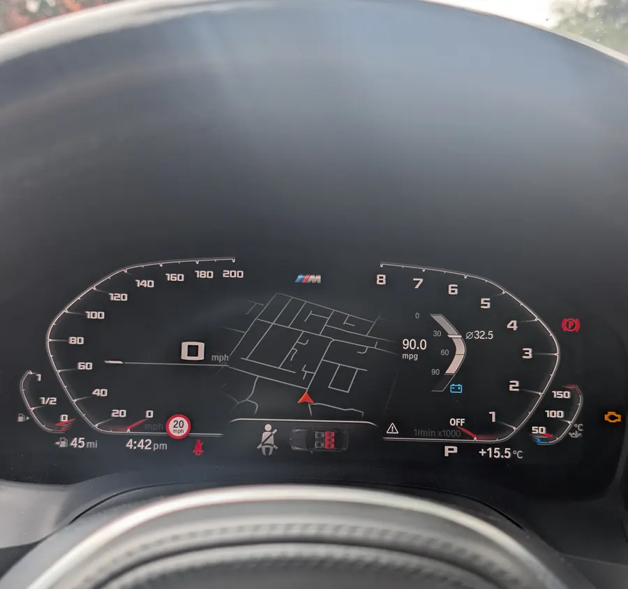 A BMW's digital instrument cluster behind the steering wheel