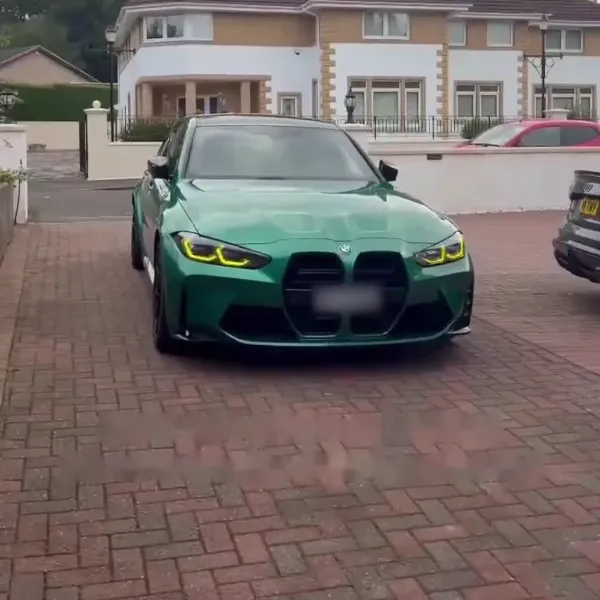 A green BMW M3 Competition on a driveway
