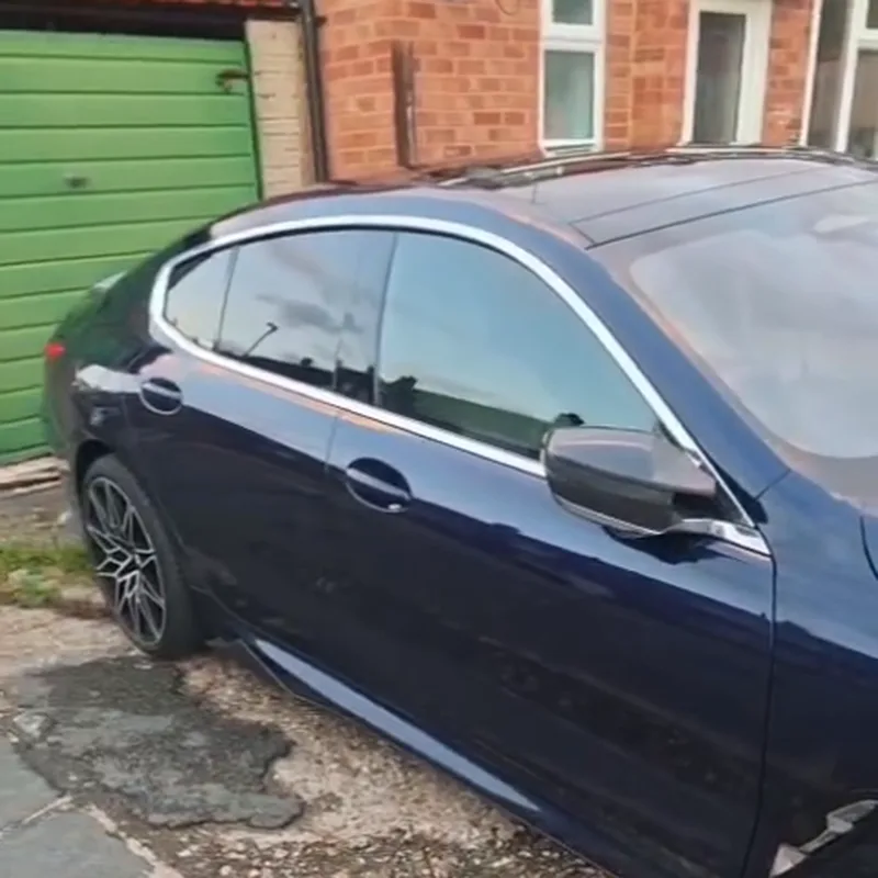A dark blue BMW 840i on a driveway